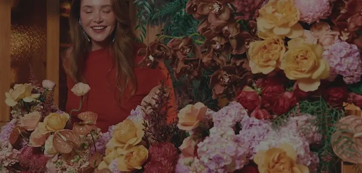 A florist surrounded by roses and peonies at Daily Blooms