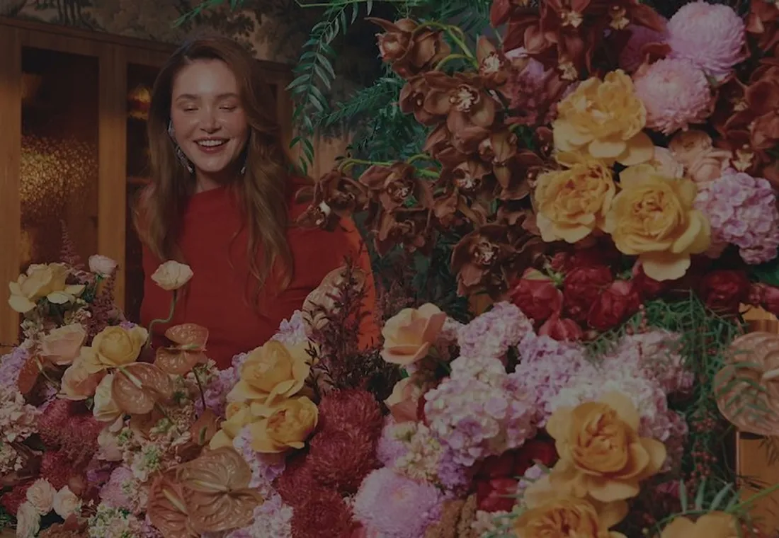 A florist surrounded by roses and peonies at Daily Blooms