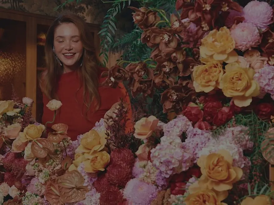 A florist surrounded by roses and peonies at Daily Blooms
