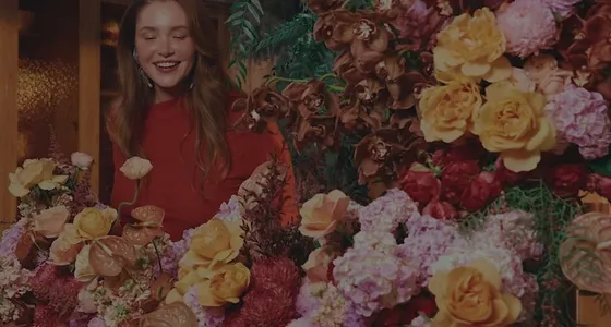 A florist surrounded by roses and peonies at Daily Blooms
