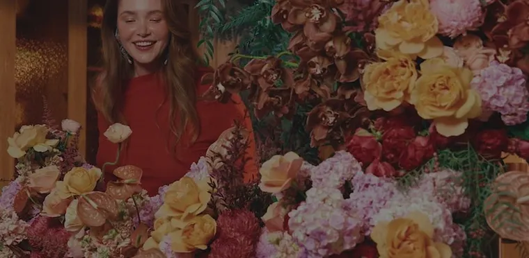 A florist surrounded by roses and peonies at Daily Blooms