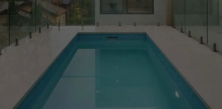 An indoor swimming pool with glass fencing, built by Mr Pools
