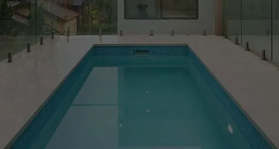 An indoor swimming pool with glass fencing, built by Mr Pools