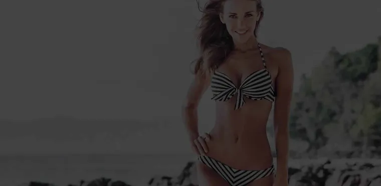 A woman on a rocky beach, from the Absolute Cosmetic body treatment campaign