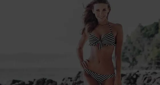 A woman on a rocky beach, from the Absolute Cosmetic body treatment campaign