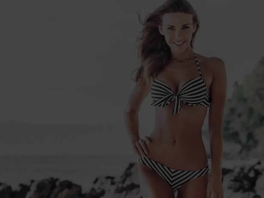 A woman on a rocky beach, from the Absolute Cosmetic body treatment campaign