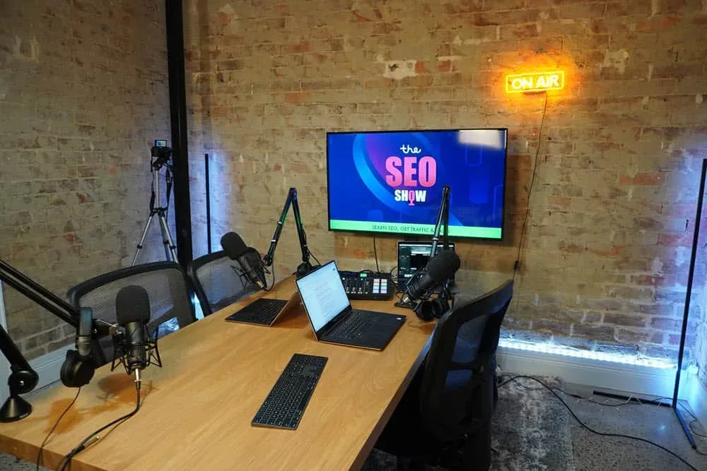 The SEO Show podcast studio with microphones, screens and an on-air sign